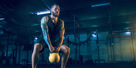 Muscular Guy Doing Kettlebell Lifts