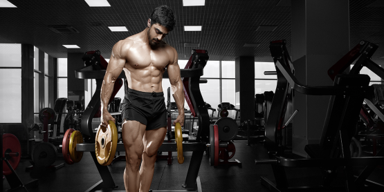 Muscular shirtless guy in black shorts holding a plate.