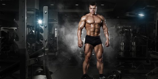 Muscular guy in black shorts going to do a deadlift